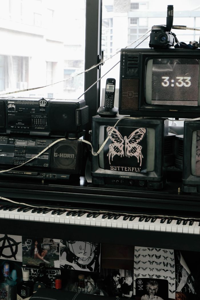 A collection of vintage electronics including TVs and a keyboard in a nostalgic retro setting.